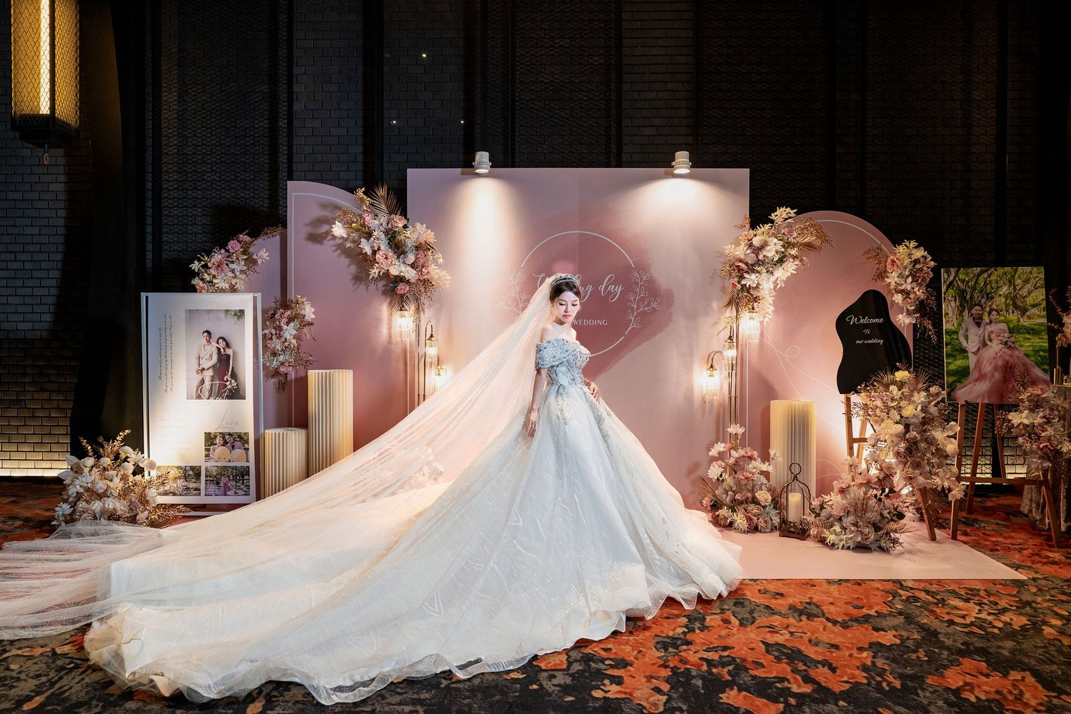 A stunning white wedding gown with a flowing train displayed in a romantic candlelit setting with floral decorations.