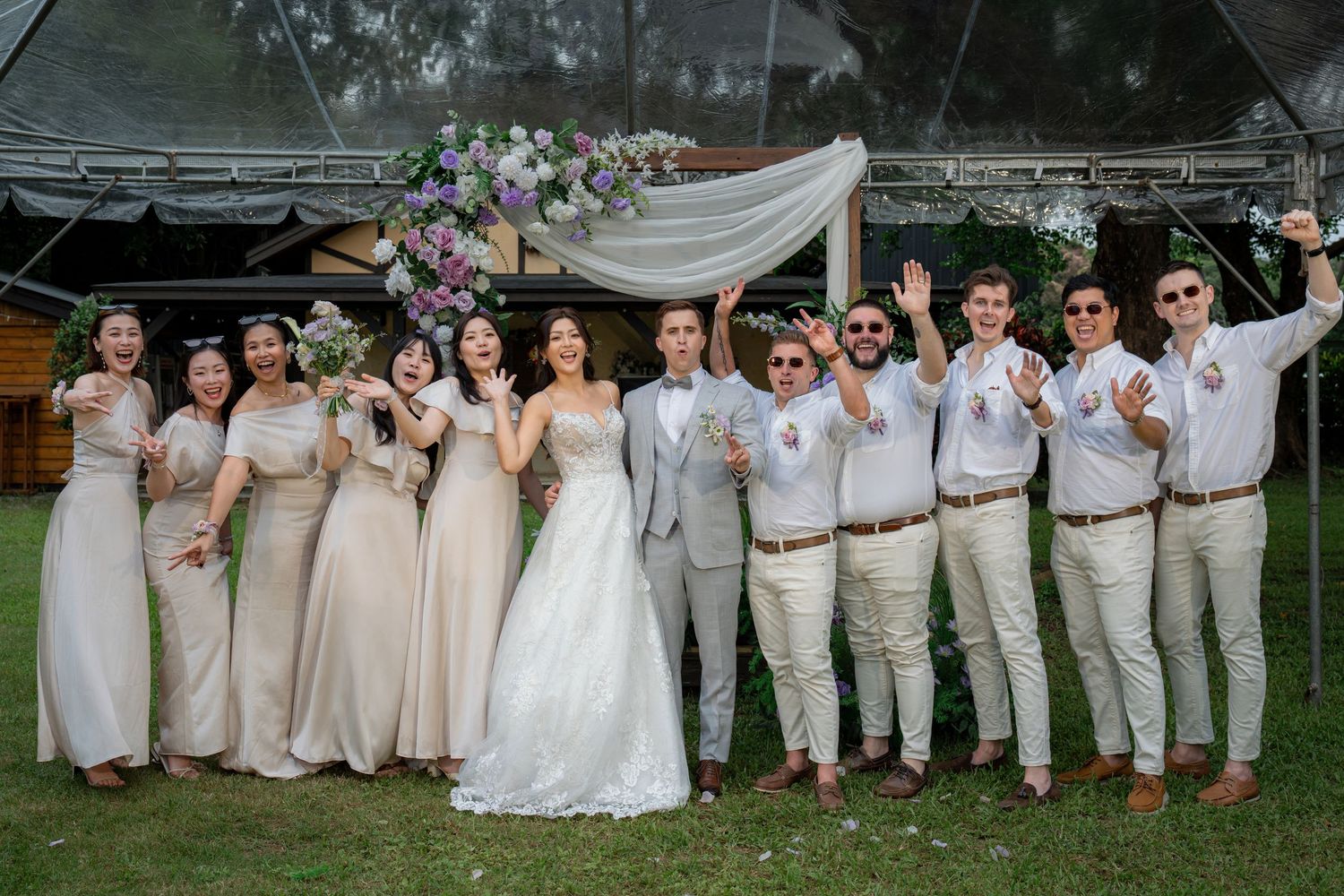 Wedding party poses outdoors, bride in white gown, groom in gray suit, bridesmaids in champagne dresses, groomsmen in white shirts.

台北婚禮攝影