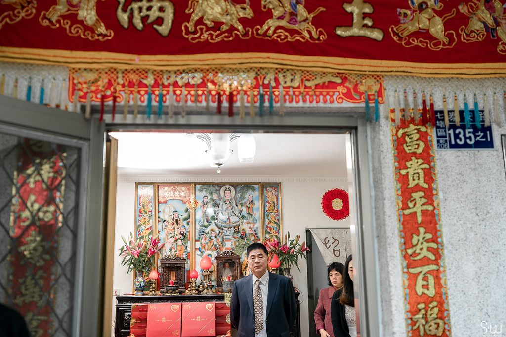 Traditional Chinese doorway decorated with red and gold banners and ornaments for a celebration.
