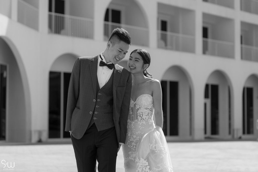 Intimate black and white wedding portrait against classic white Mediterranean architecture.