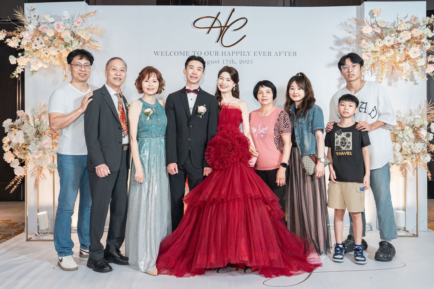 Group photos in coordinated formal attire stand together against a soft floral backdrop.
