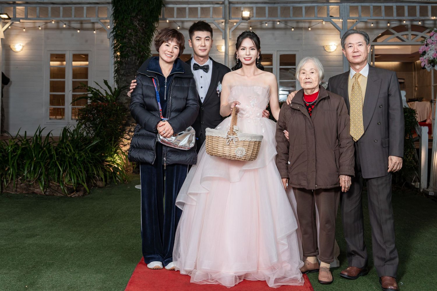 People in formal attire gather at an elegant indoor event with warm lighting and decorative elements.