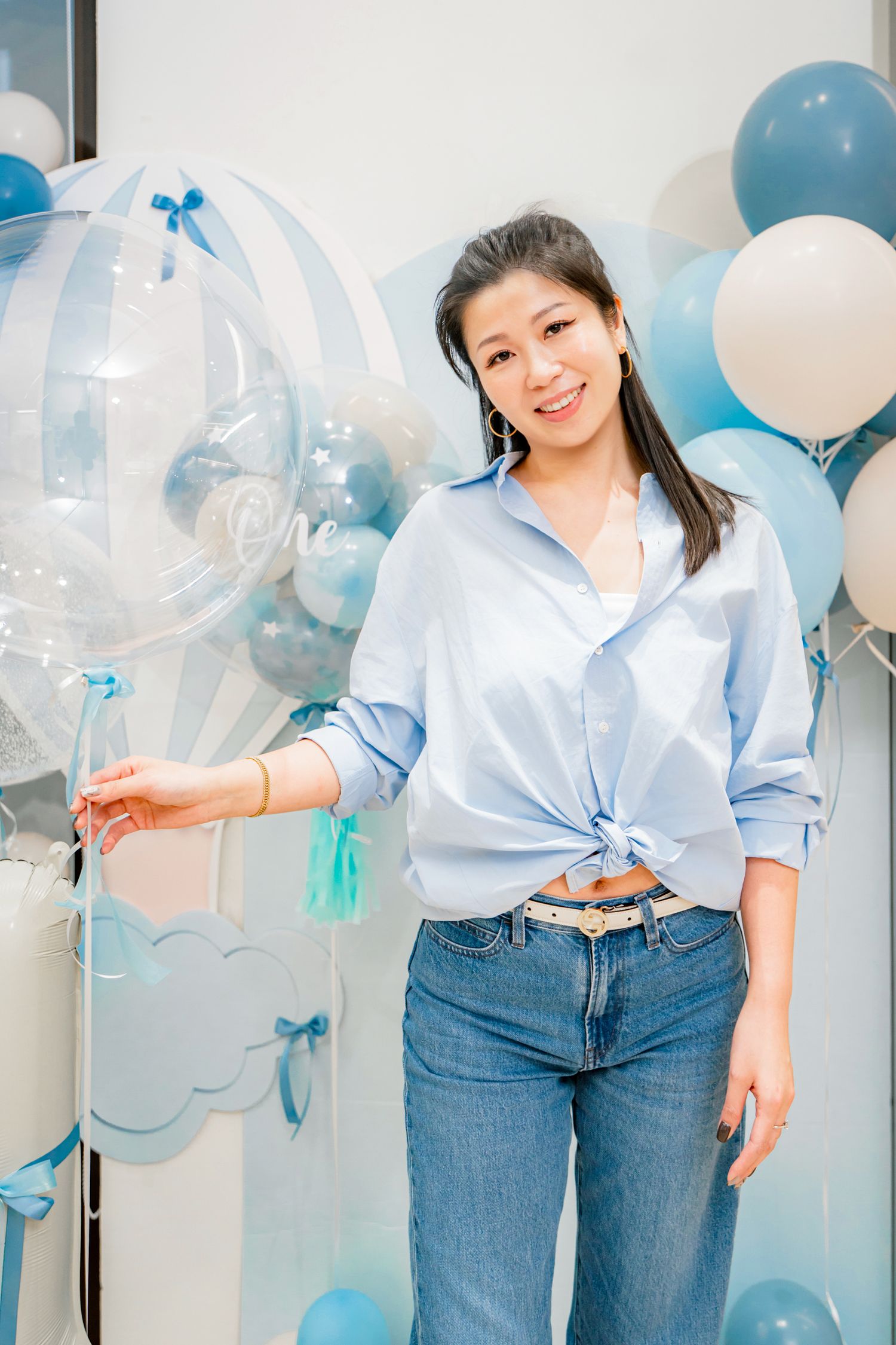 A festive party setup with blue and white balloons creating a cheerful atmosphere against a light background.