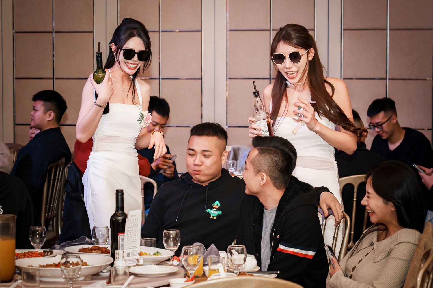 A group of people seated at a long dining table enjoying a meal together at a restaurant.