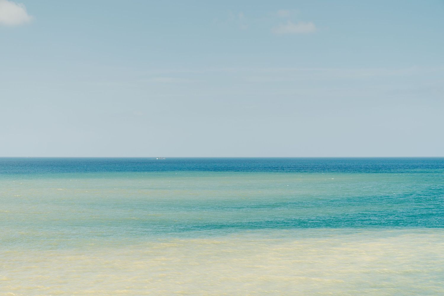 Serene ocean horizon with turquoise blue waters meeting the sky in a tranquil minimalist seascape.
