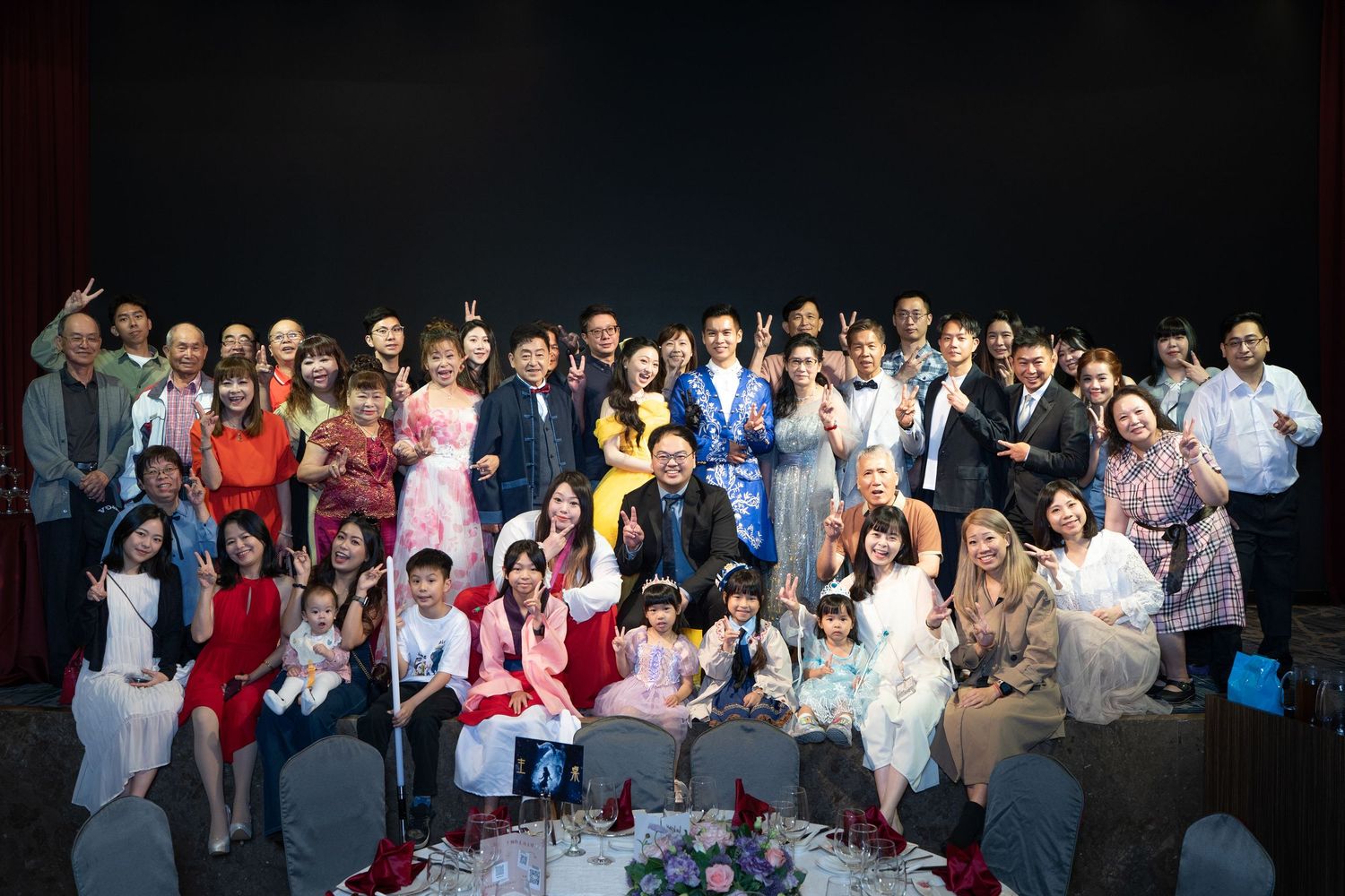 Large group of people posing together for a formal group photo at a celebratory event or gathering.