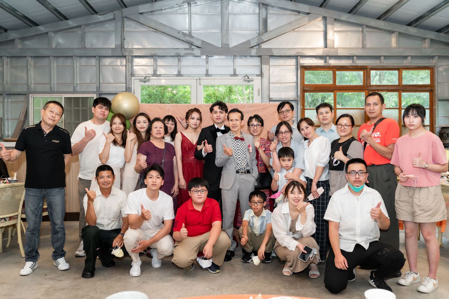 Group celebration photo in a bright warehouse-style venue with natural lighting.