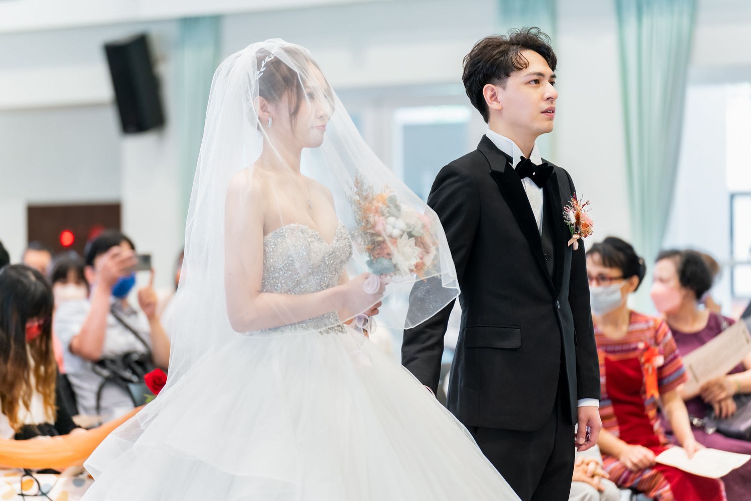 Wedding ceremony in progress with couple in traditional attire on display.
