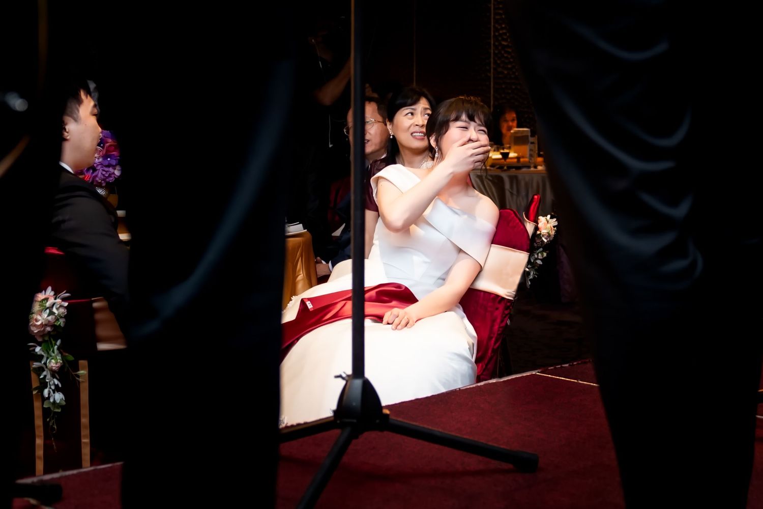 A spotlight illuminates newlyweds sharing an intimate moment on stage.
