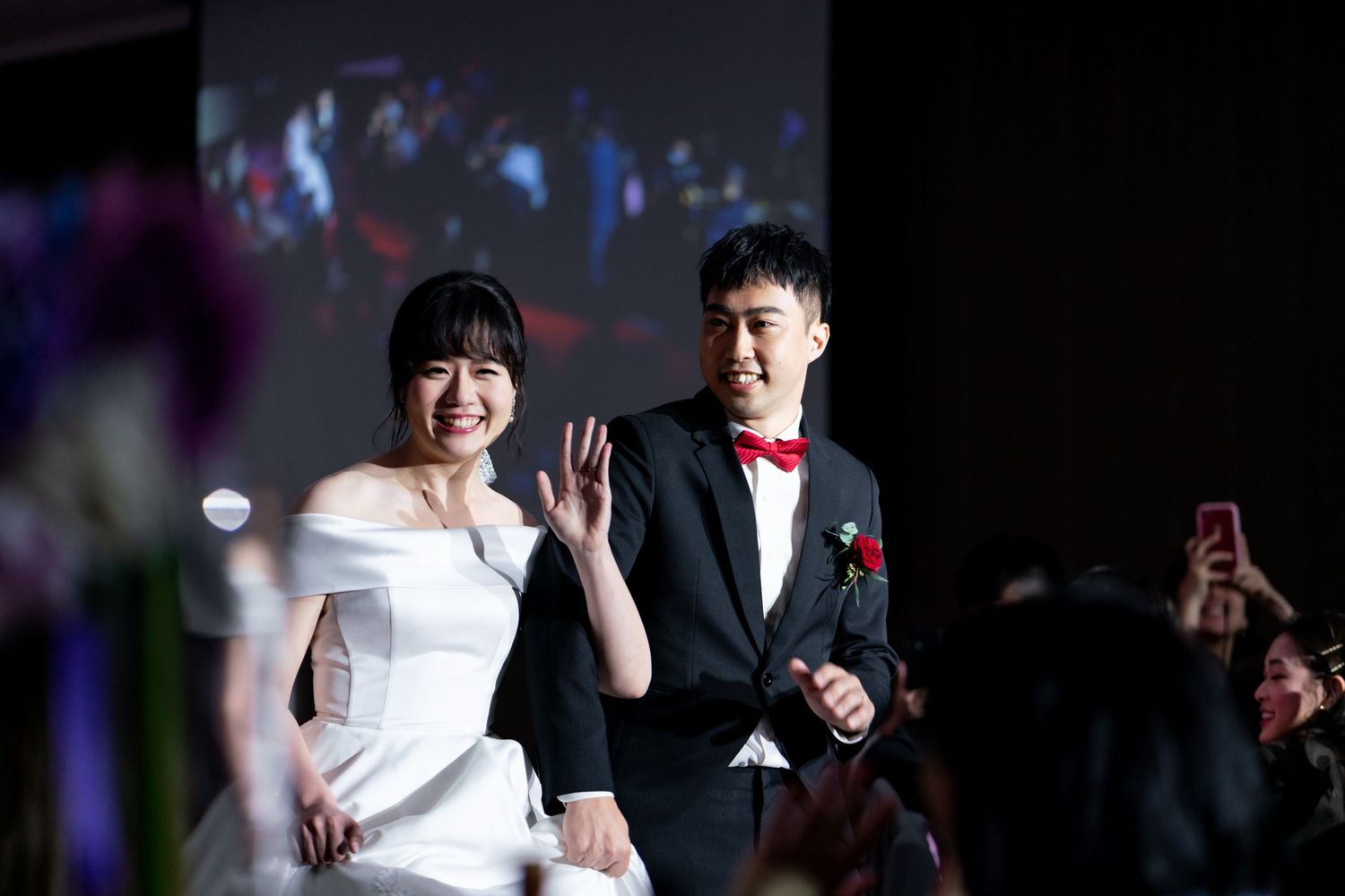 Wedding celebration moment captured during reception with bright spotlighting.