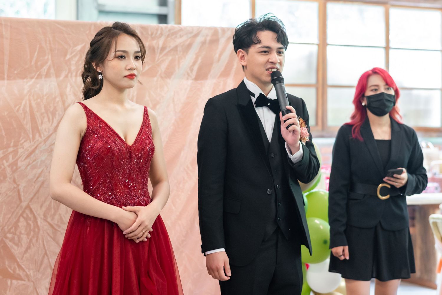 Formal event speakers in evening wear addressing audience.