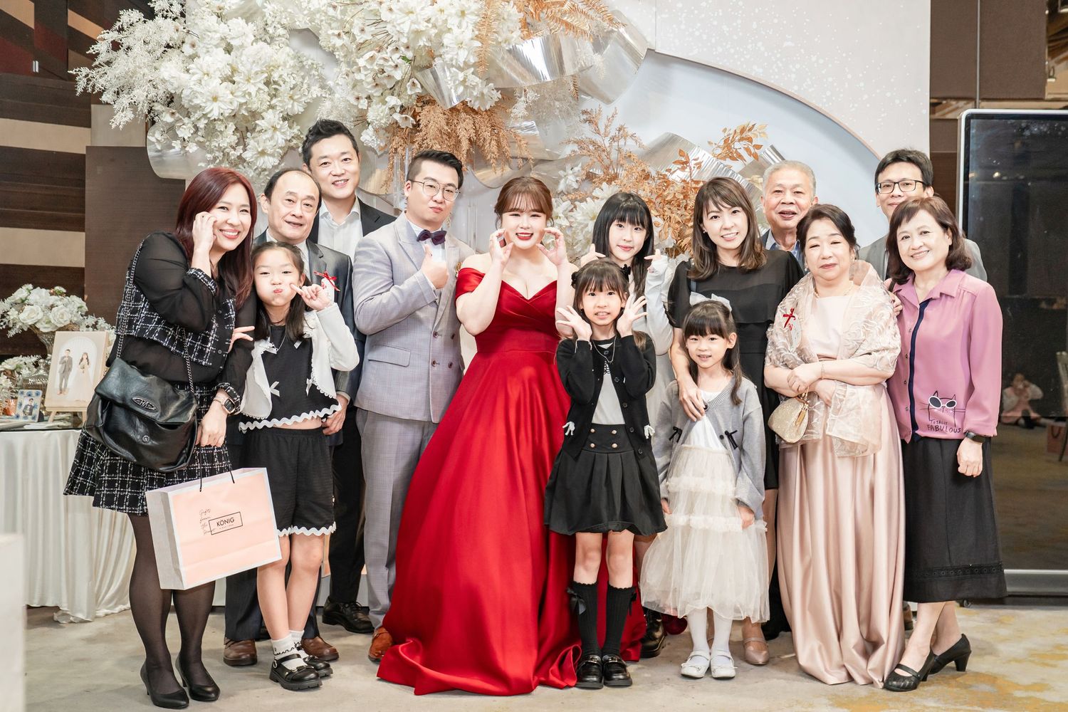 A group of people gathered at an elegant event wearing formal attire and standing together for photos.