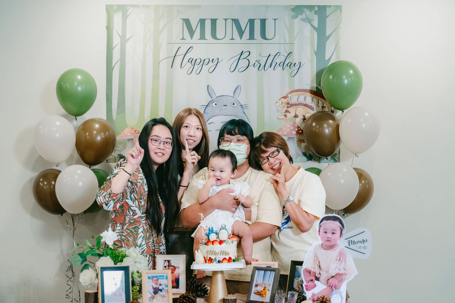 A celebratory birthday party setting with green and white balloons decorating a room with a 