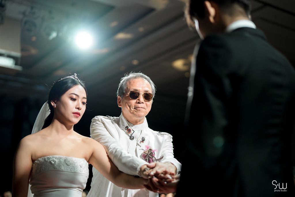 Emotional wedding moment captured during reception with guests in formal attire.