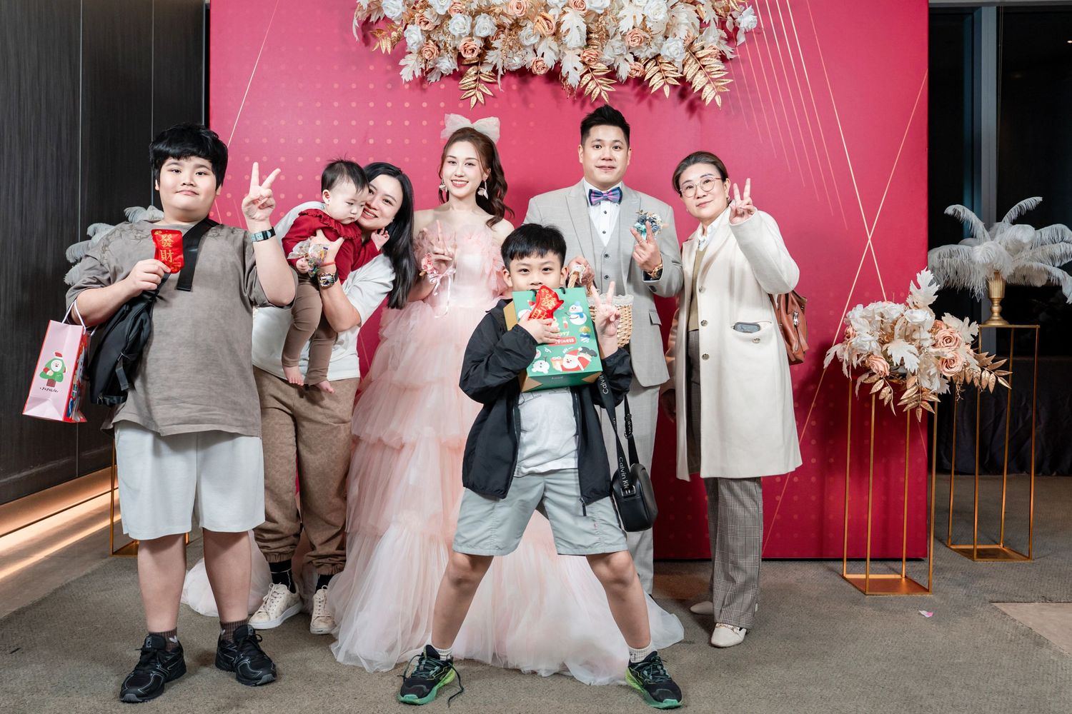 A series of wedding party photos showing guests posing against pink and grey backdrops at an elegant celebration.