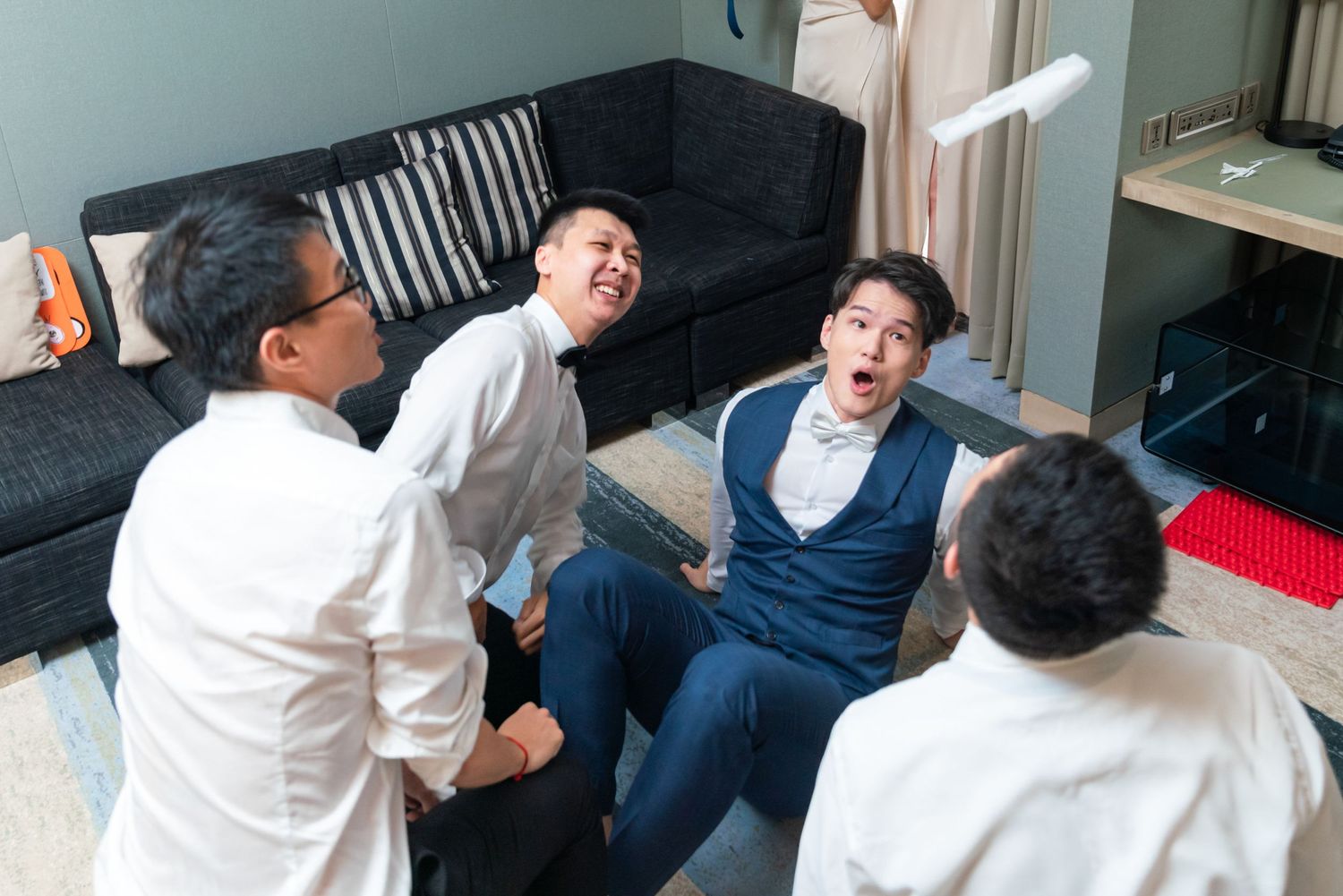 A group of people sitting in a living room sharing laughter and conversations on a dark couch.
