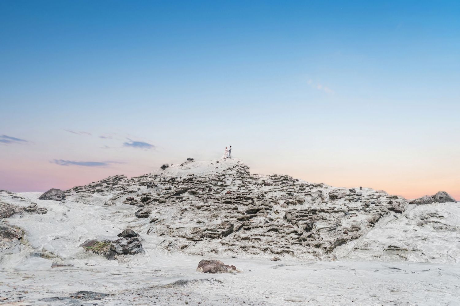 A panoramic view of snowy mountain peaks and ridges against a clear blue sky during winter.