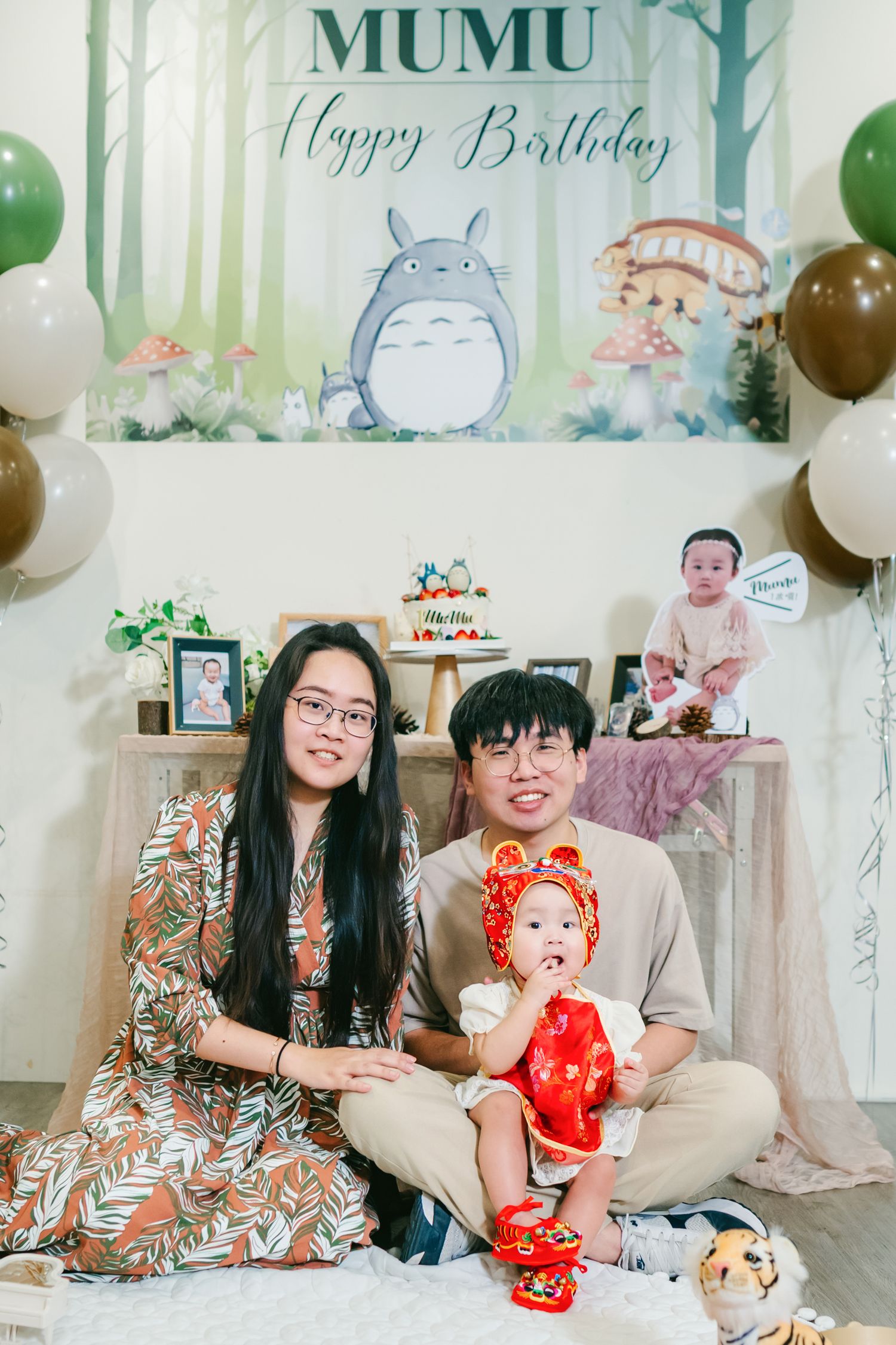 A birthday party setting with Totoro backdrop, colorful balloons, and festive decorations for MUMU's celebration.