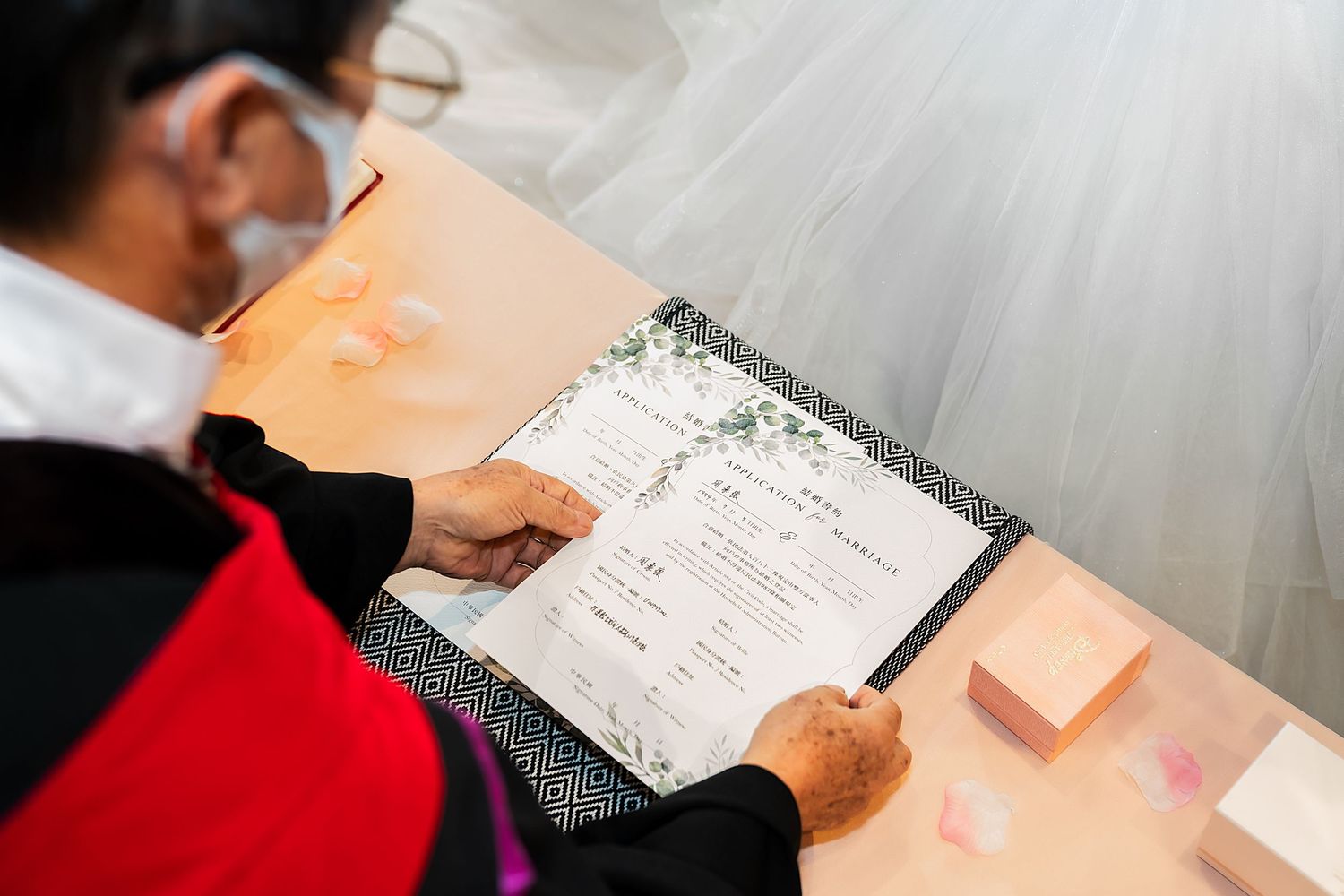 An officiant signs a marriage certificate during a wedding ceremony.