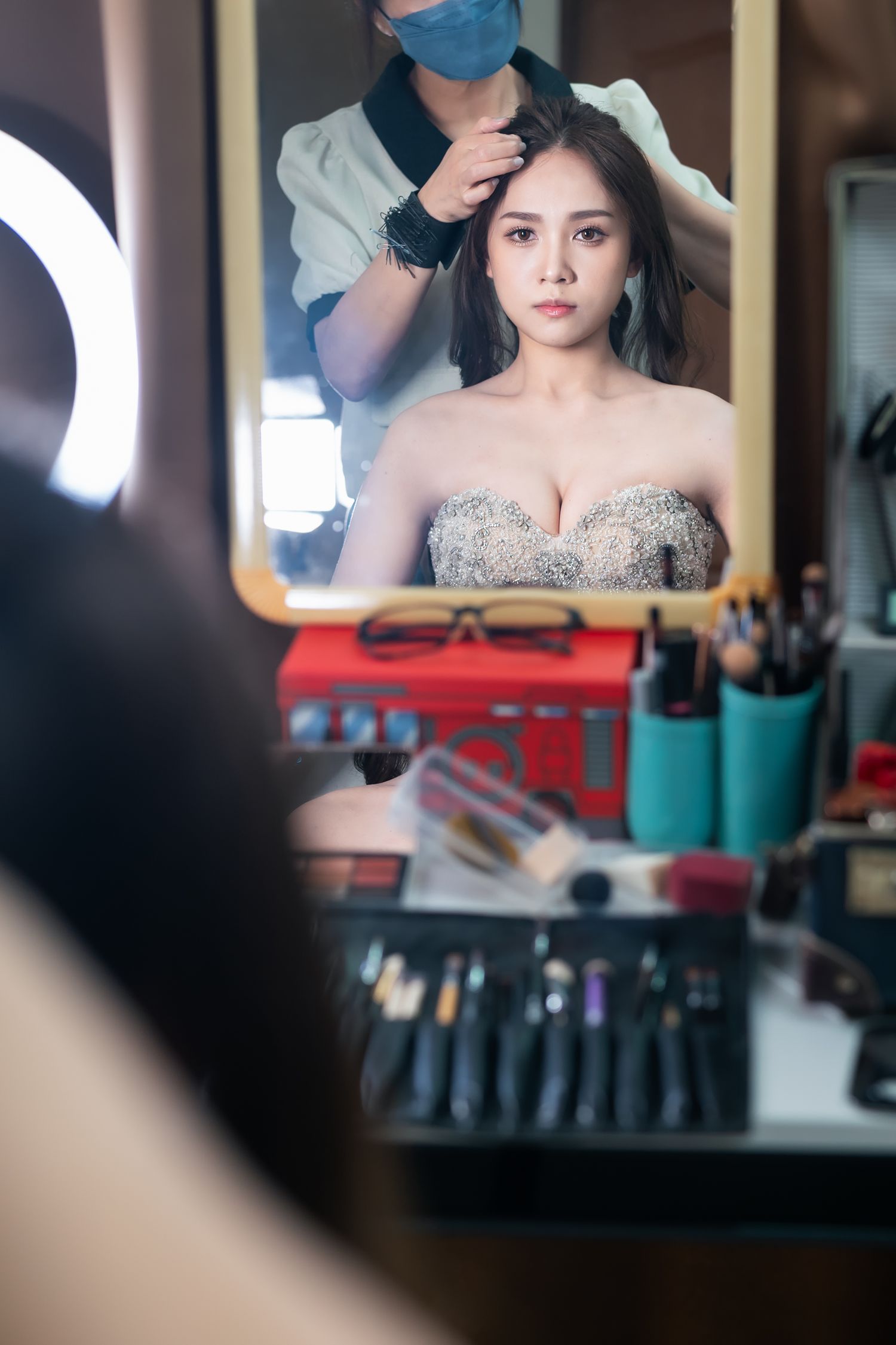 Behind-the-scenes shot of bridal makeup preparation with professional styling tools.