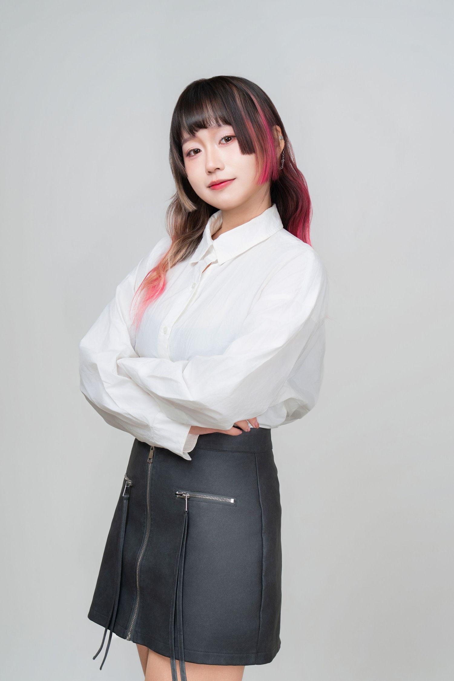 A figure in a white button-up shirt and black miniskirt poses against a light gray background in a fashion series.