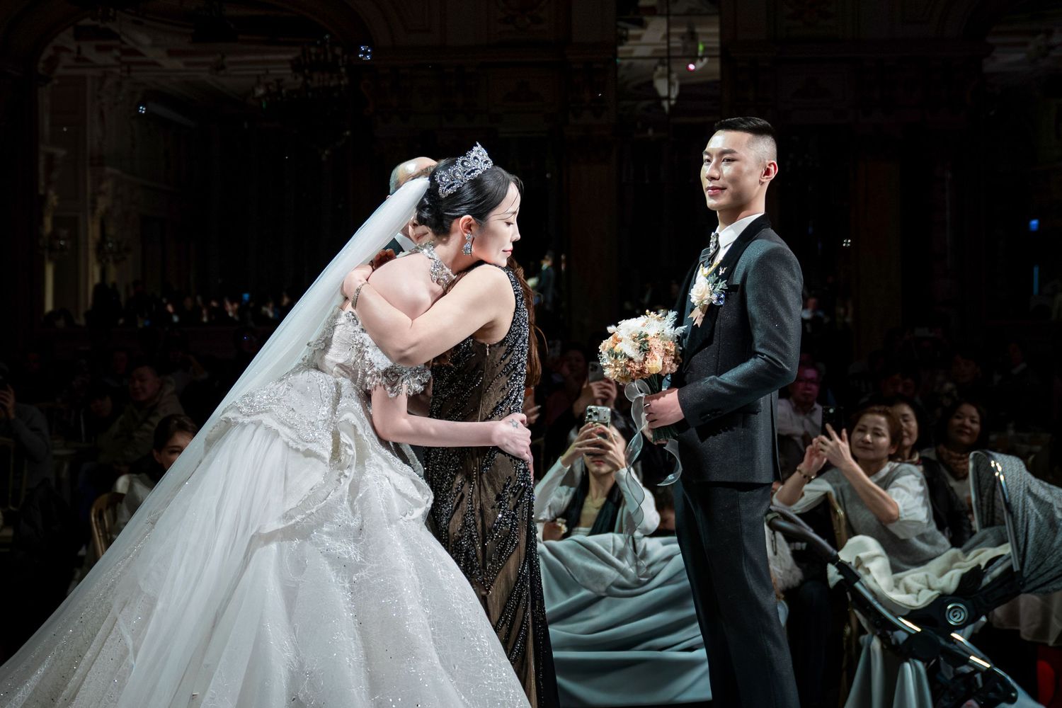 A couple performs their first dance at a wedding reception in an elegantly lit ballroom.
