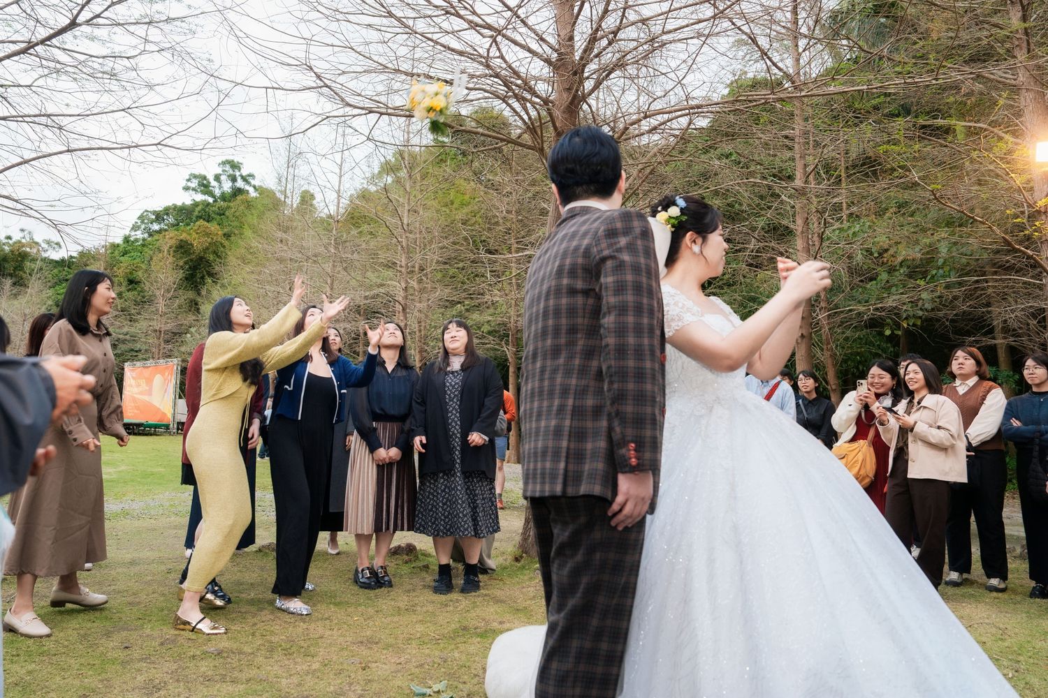 A group of people dancing together in a line at an outdoor event during daytime.