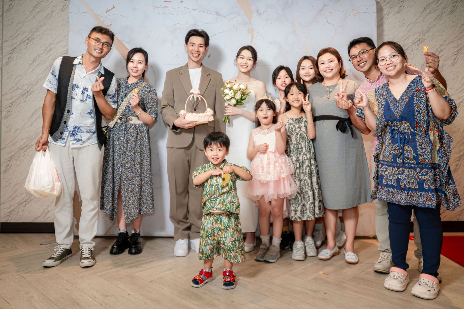 A group of family and friends pose together holding drinks at a celebratory gathering with festive attire.