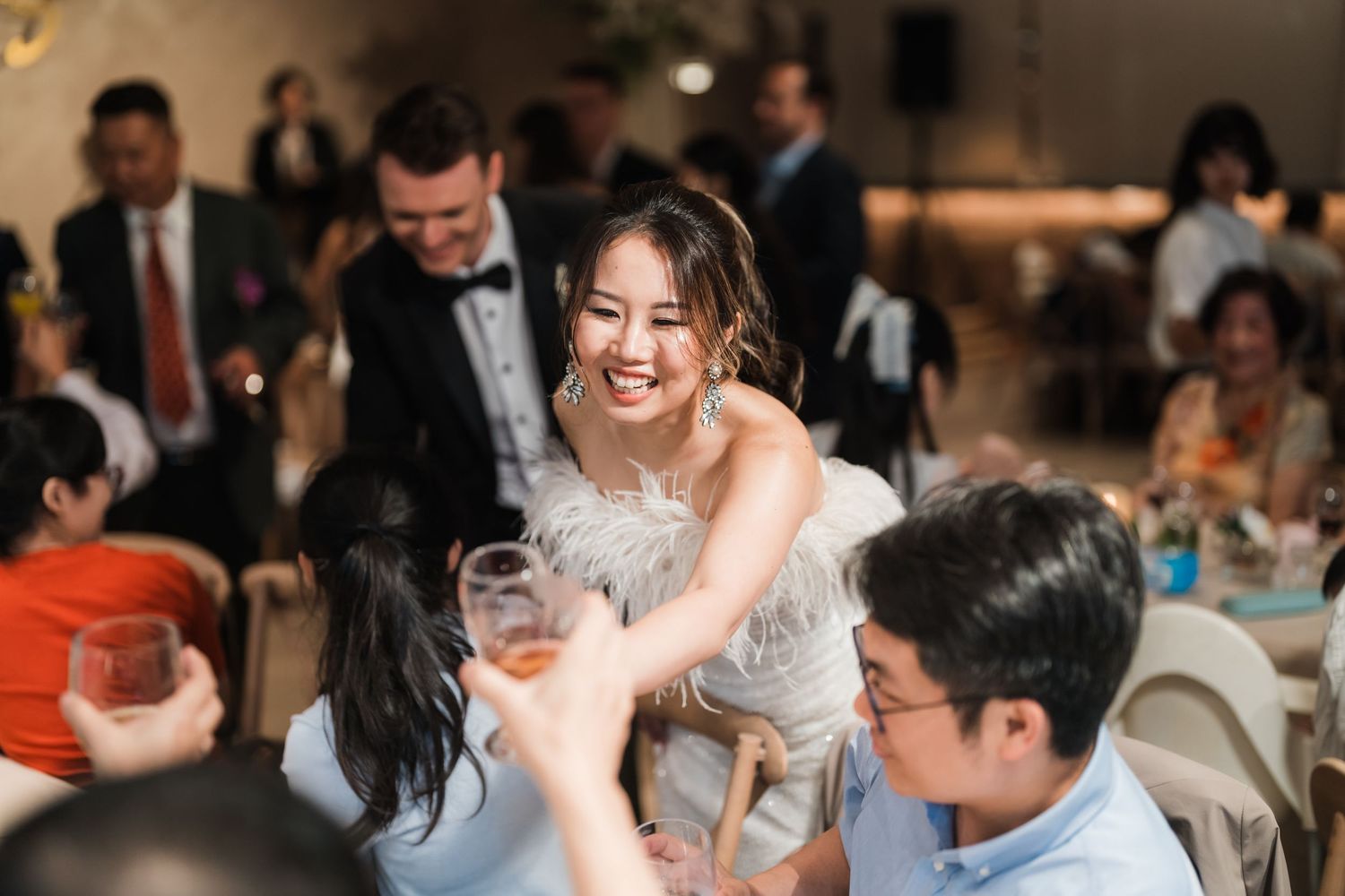 Candid wedding reception moments captured as guests mingle and dance during an evening celebration.