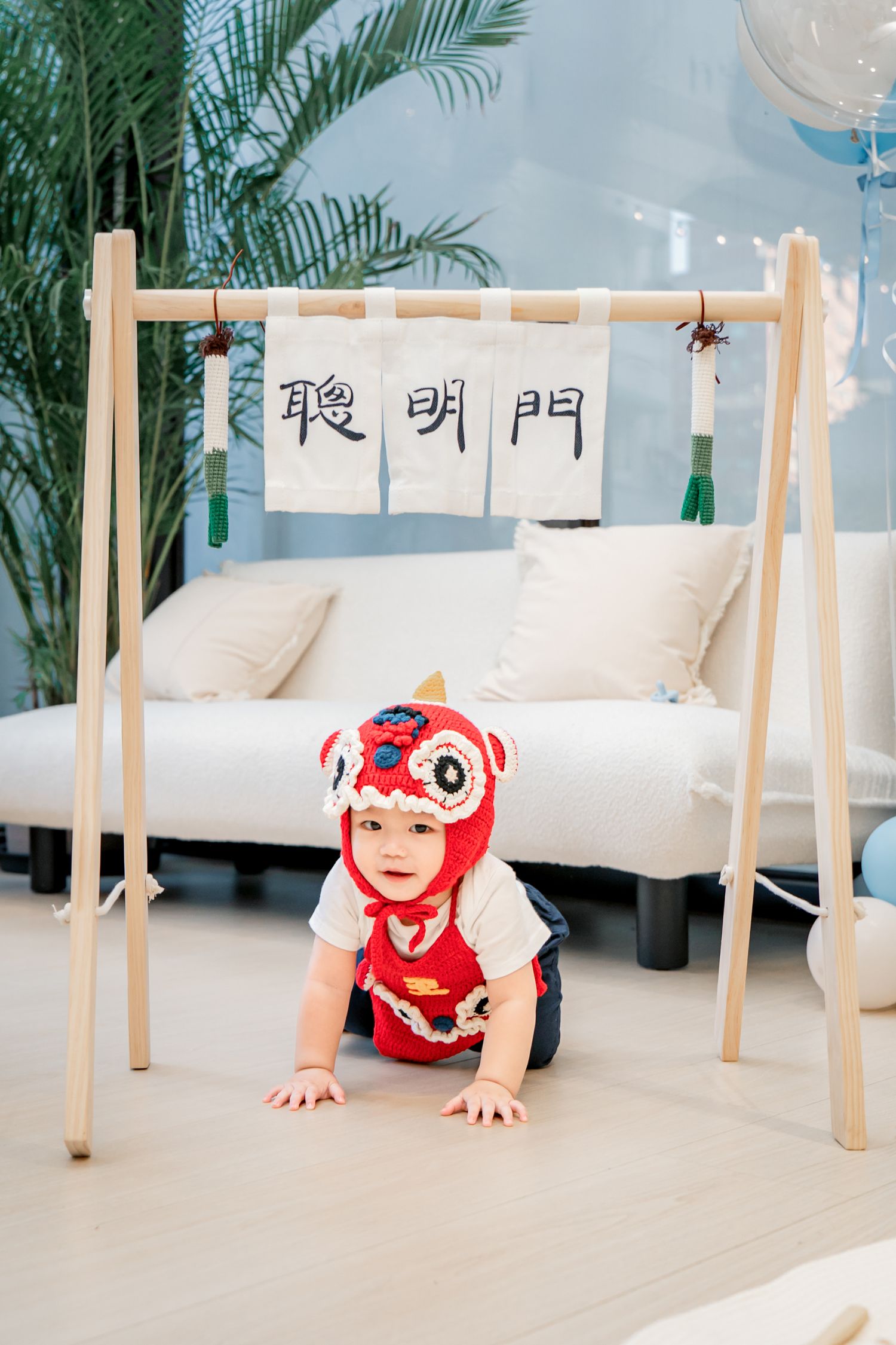 A sequence of photos showing someone in a red shirt crawling under white tables on a light colored floor with palm plants visible.
