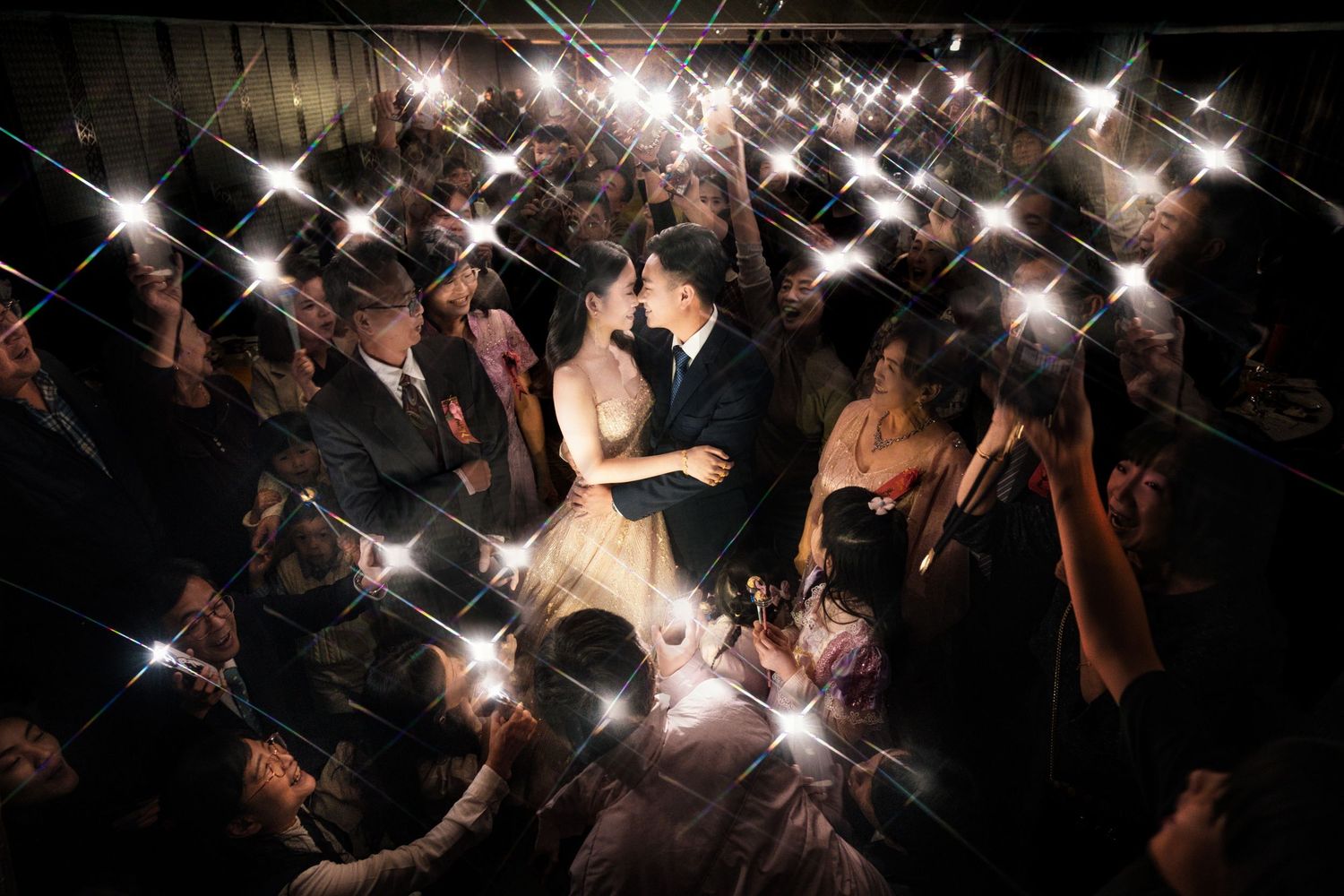 Twinkling lights and sparkles create a magical effect against a dark background in a crowd setting.