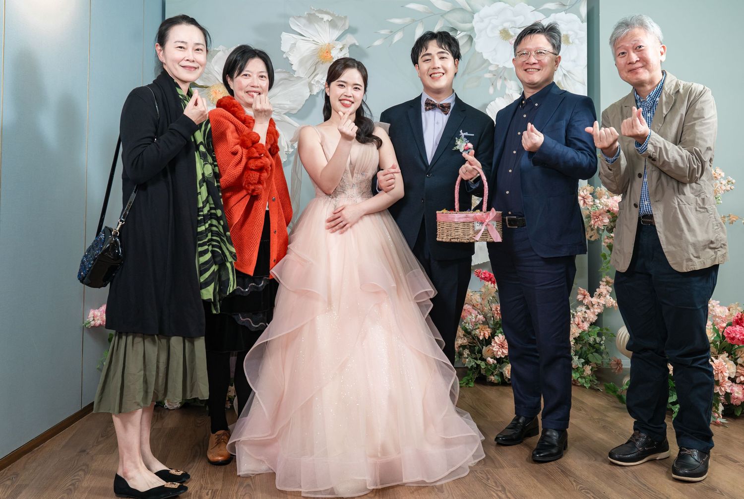 Wedding celebration scene showing guests in formal attire gathered together at an indoor venue.