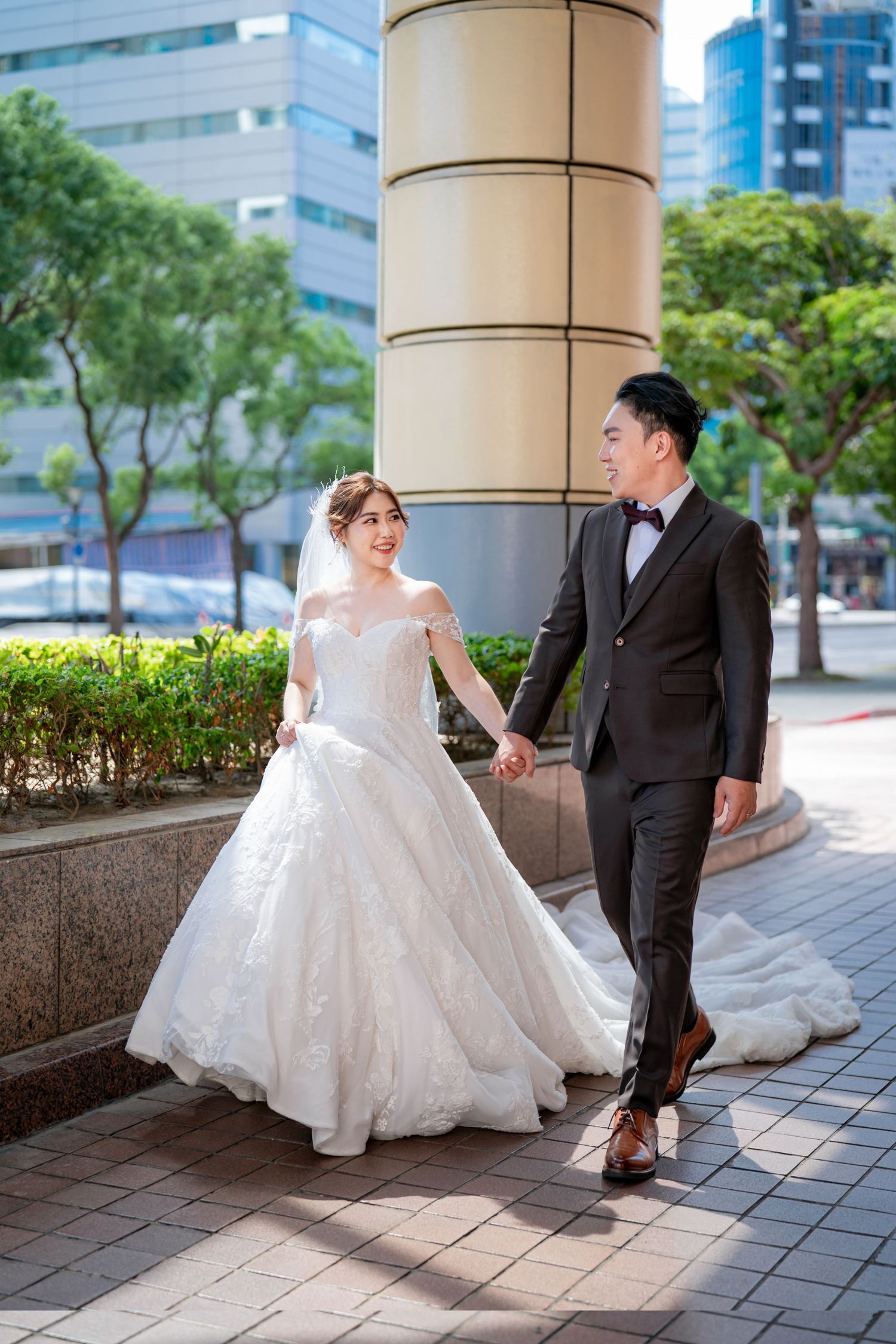 A romantic wedding photo sequence showing a couple dancing together in an urban setting with architectural columns.