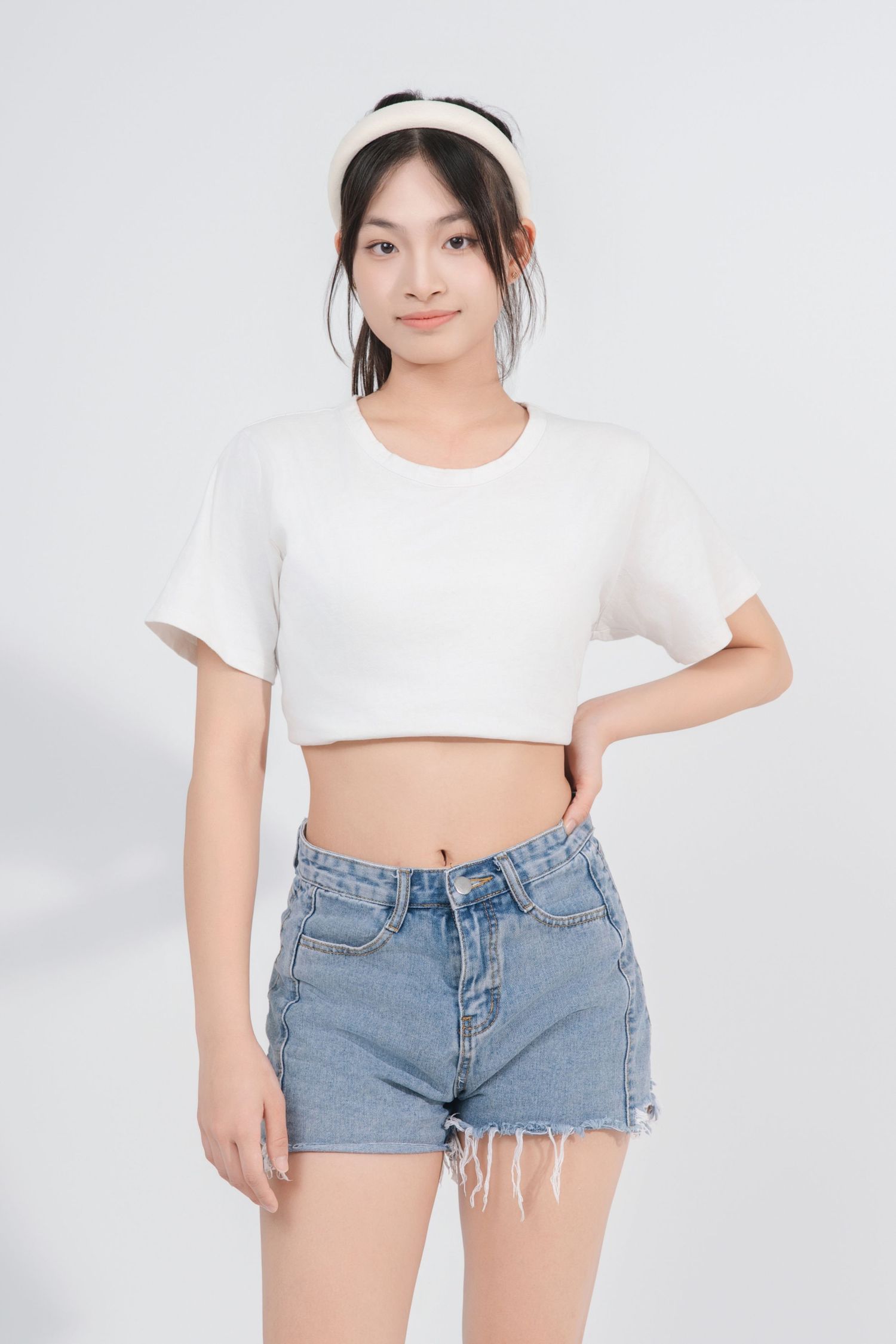 A series of fashion photos showing a white crop top and distressed denim shorts outfit against a light background.