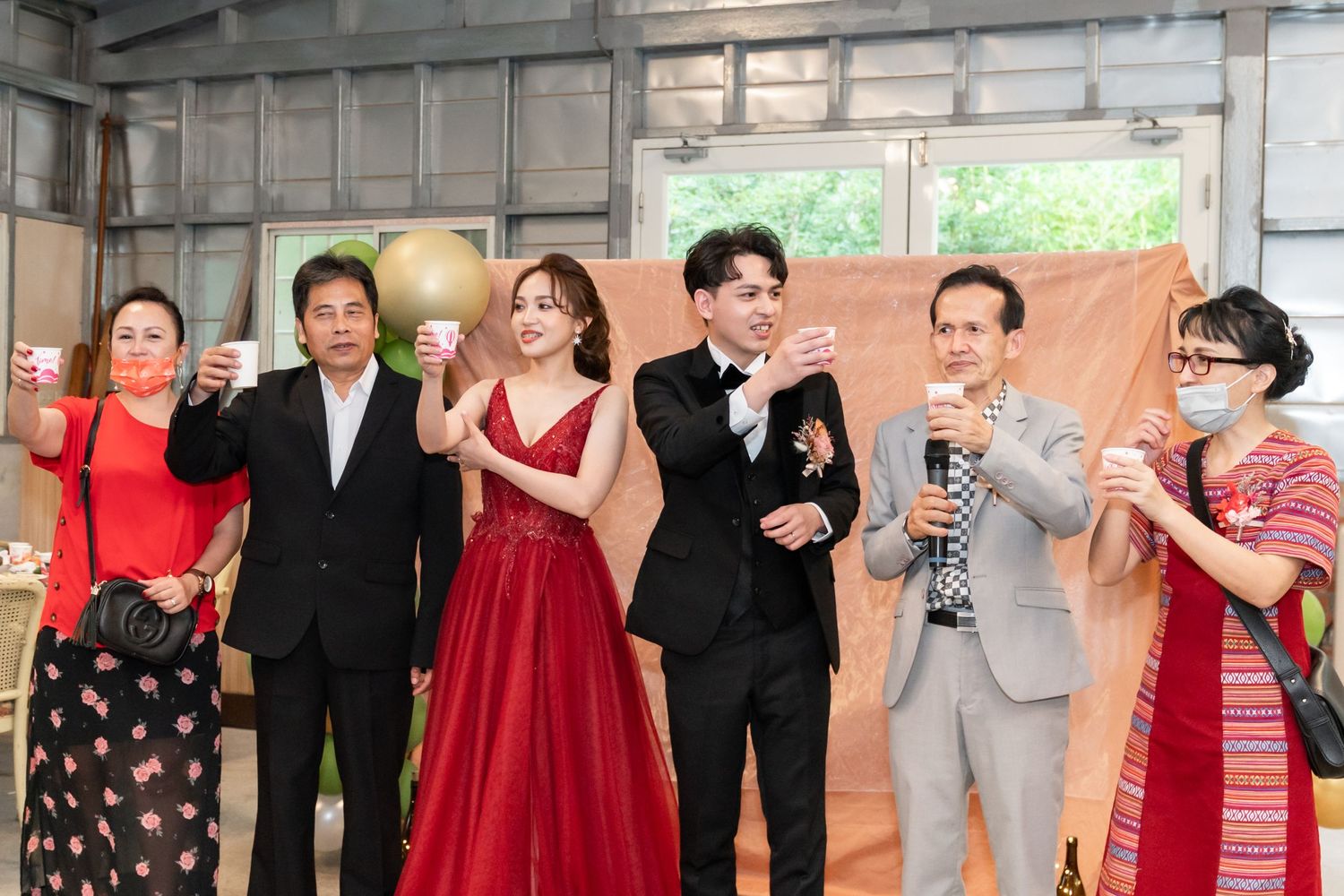 Wedding celebration group photo with guests in formal attire.