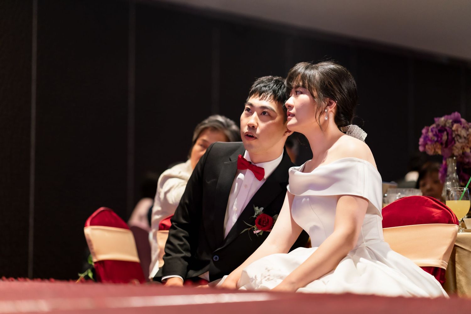 A couple shares a joyful moment during their wedding reception.