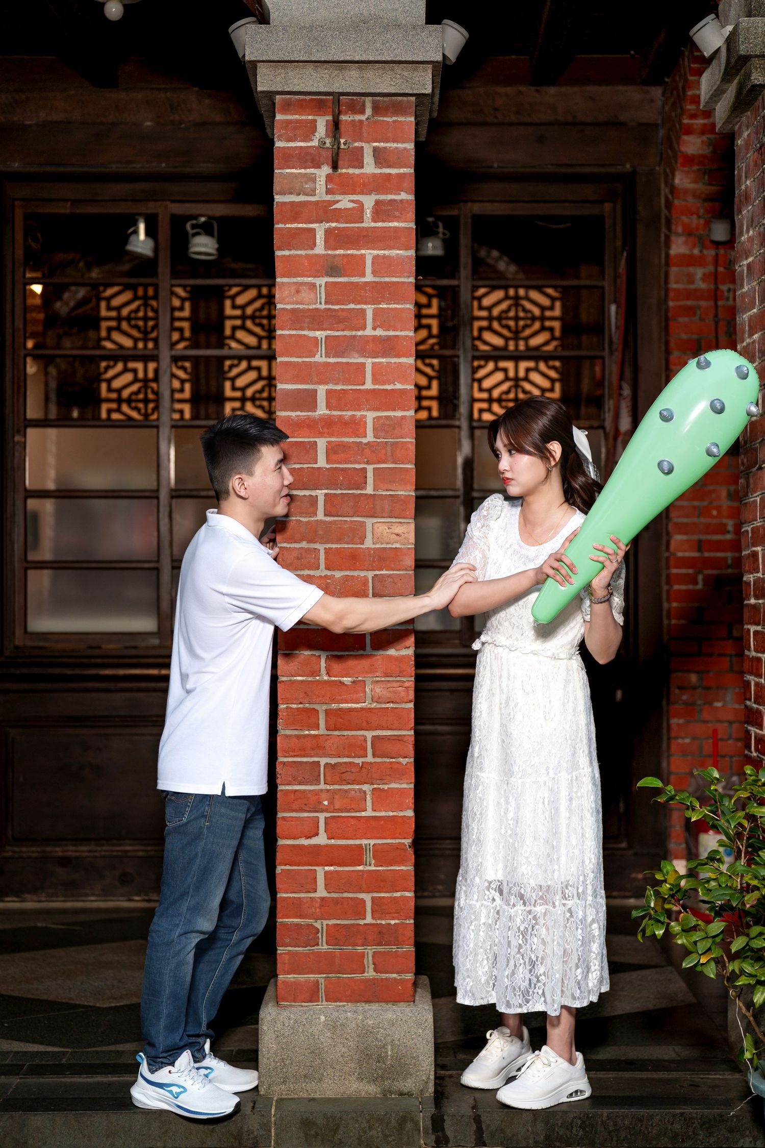 A playful sequence of images showing two people dancing with a green inflatable dinosaur against a brick wall.
