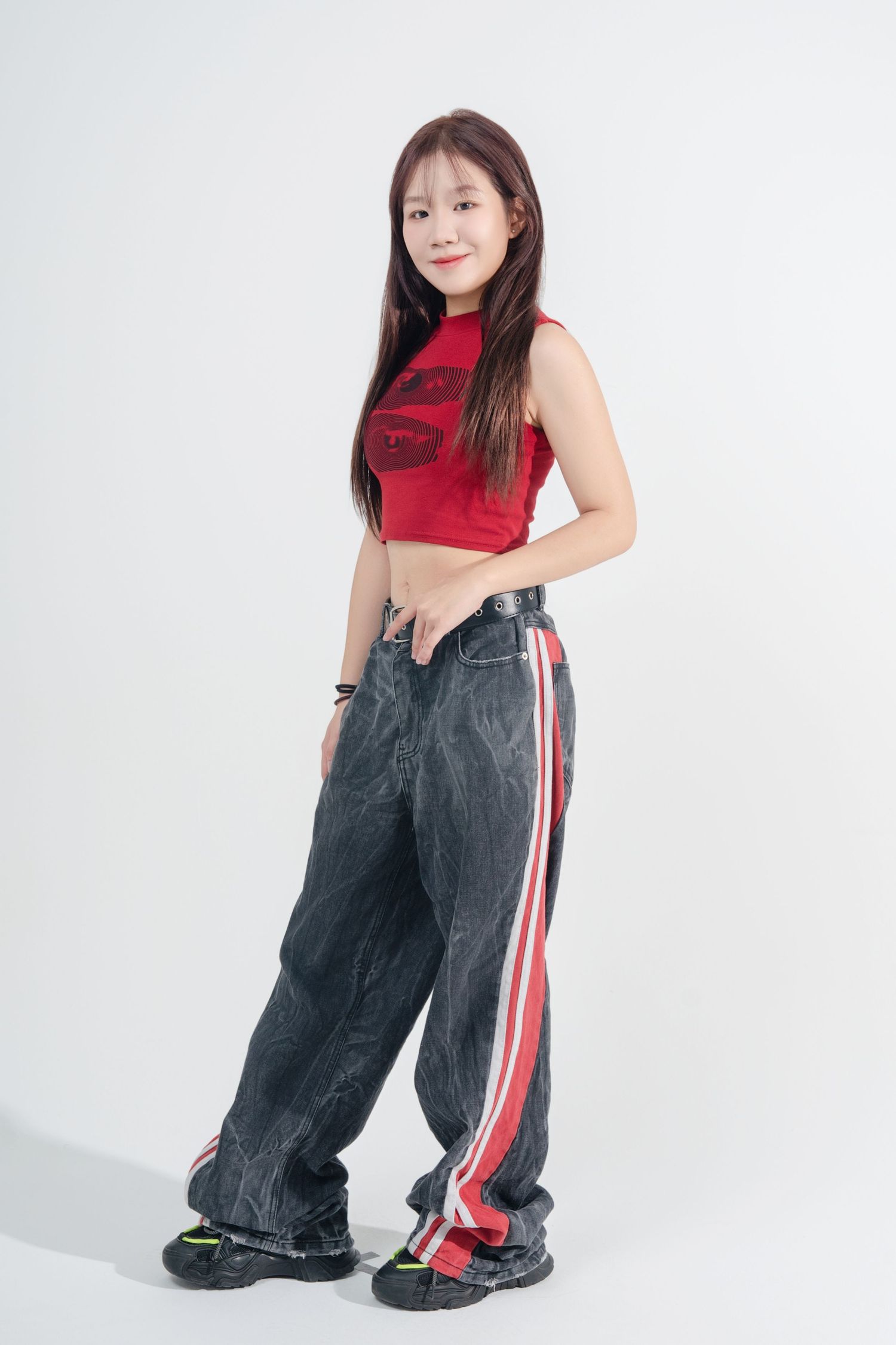 Model wearing a red crop top and baggy dark denim jeans with red and white side stripes in various poses.