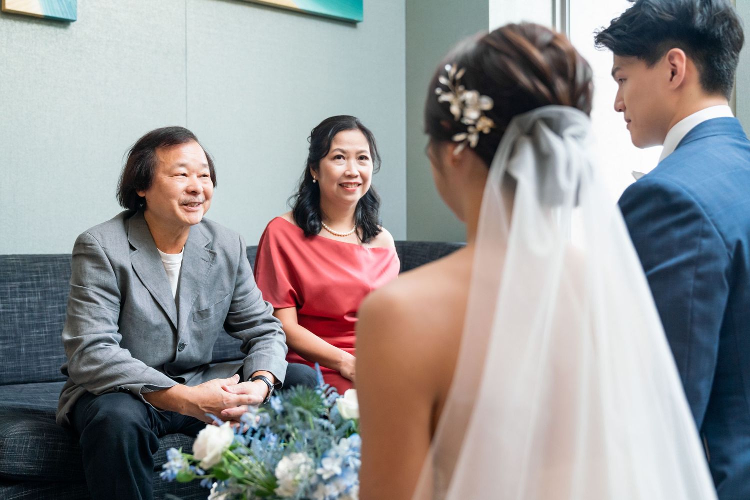 Wedding guests share a joyful moment during conversation at an indoor celebration event.