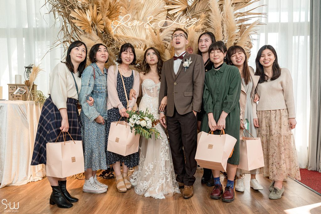 Wedding group photo with rustic pampas grass backdrop and coordinated casual attire.