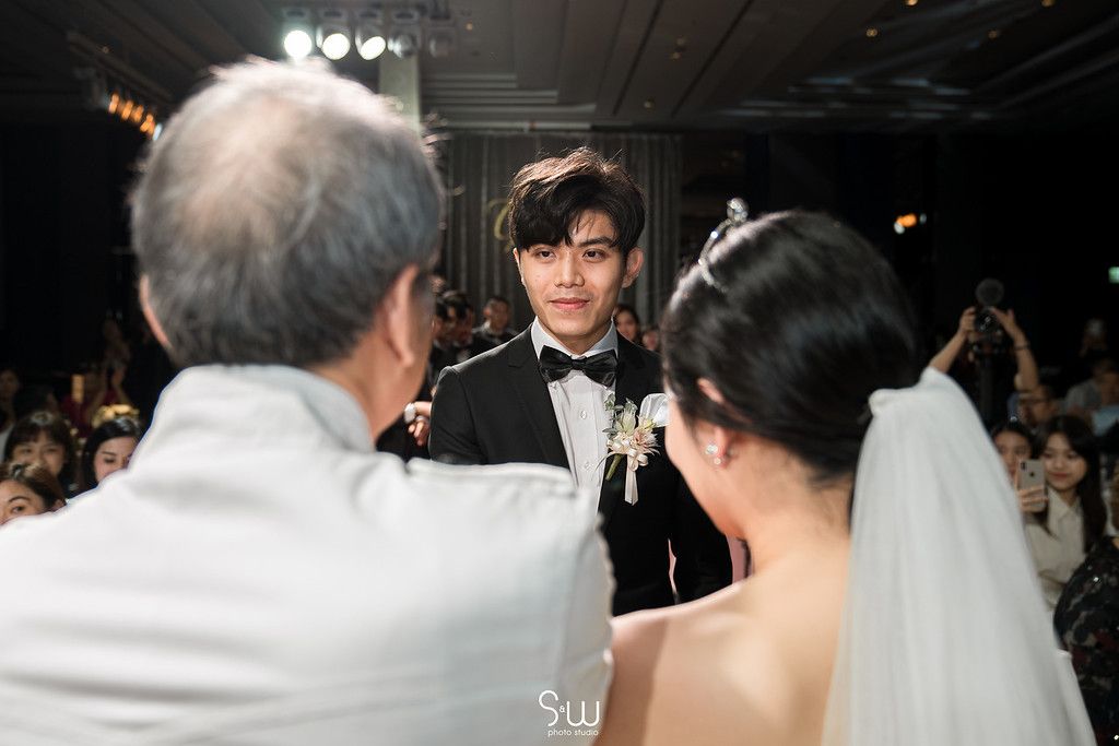 Wedding ceremony moment captured with guests and couple in elegant venue setting.
