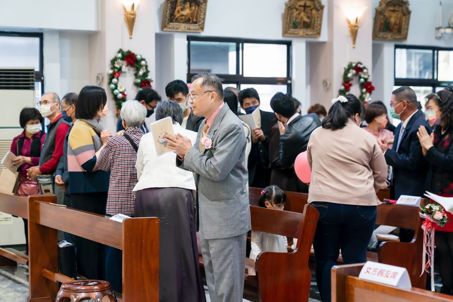 Church congregation gathering during wedding ceremony.