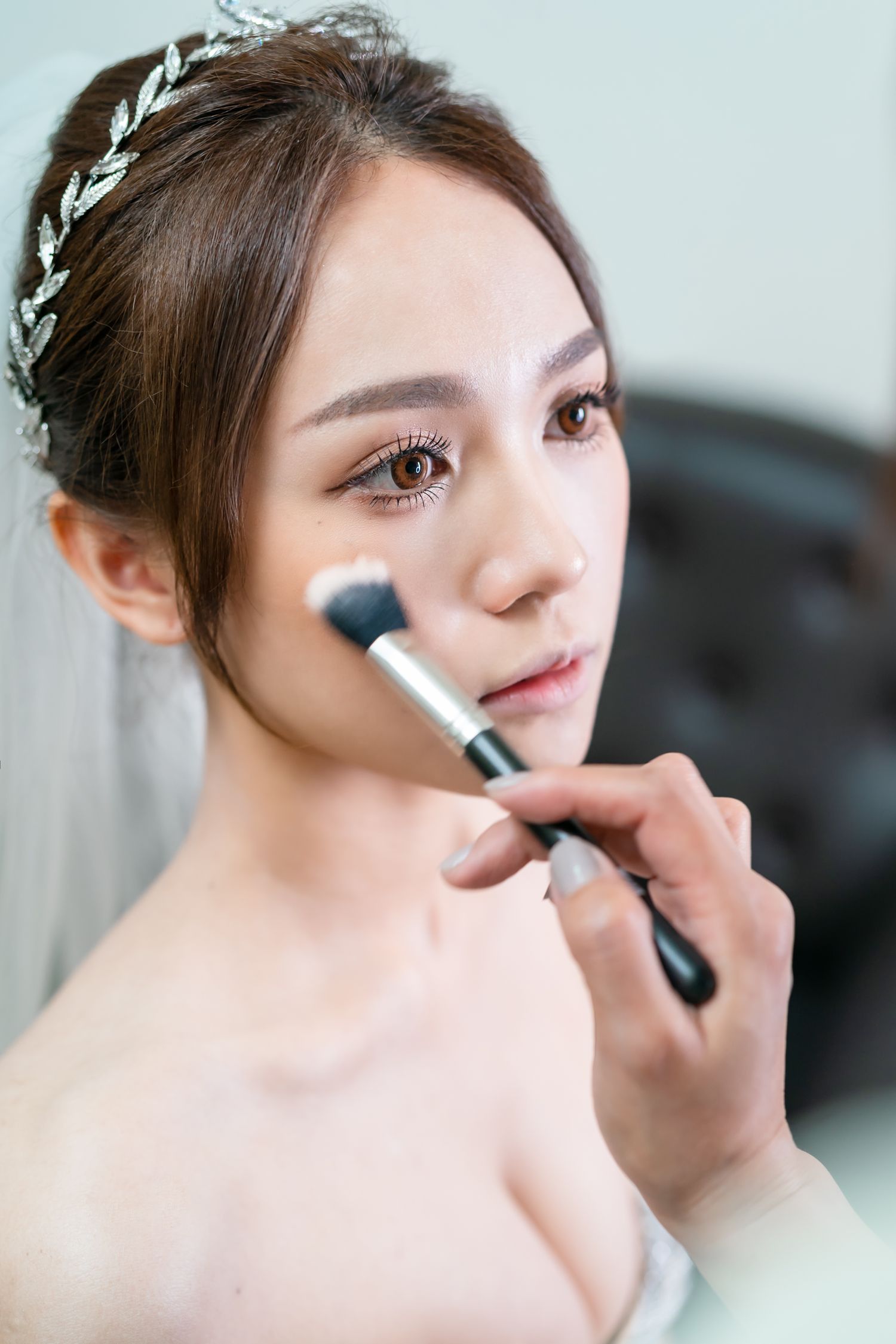 Close up of bridal makeup application with a fluffy brush.