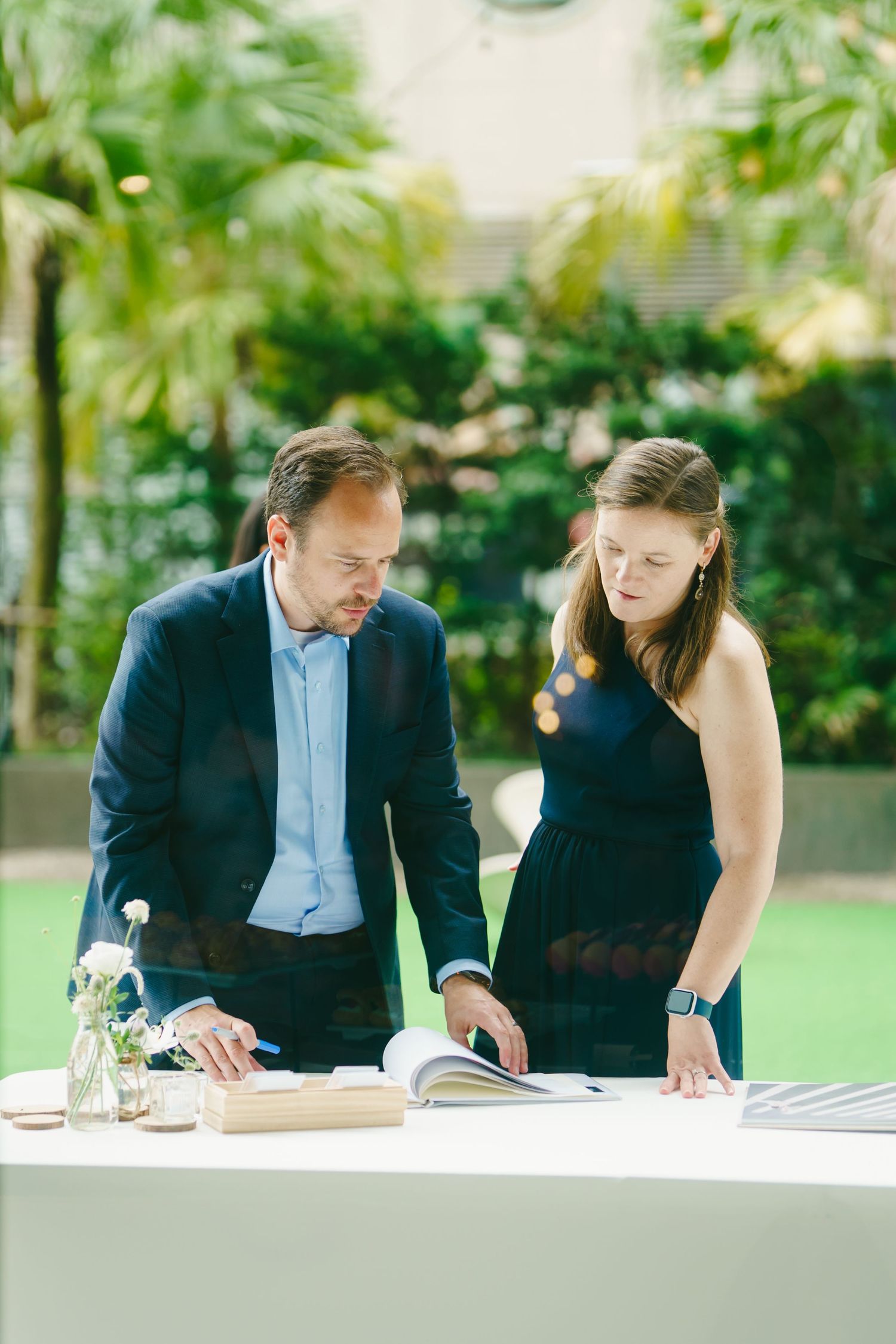 Two business professionals sitting at table reviewing documents together in office setting.