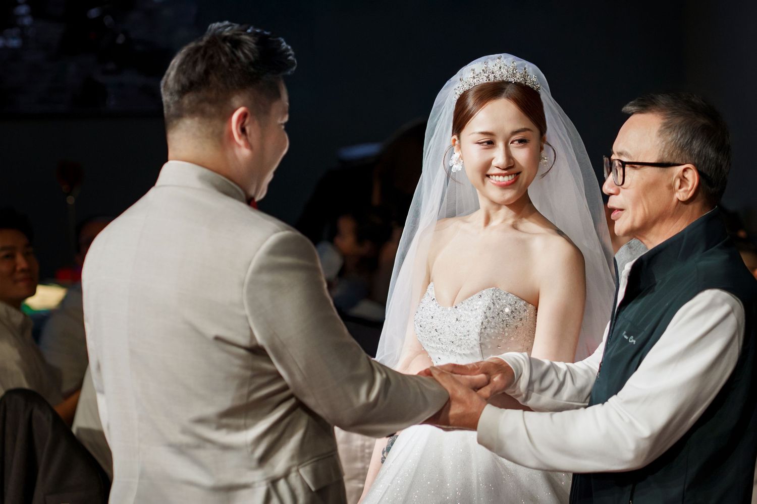 A wedding couple shares their first dance together in a dimly lit reception venue.