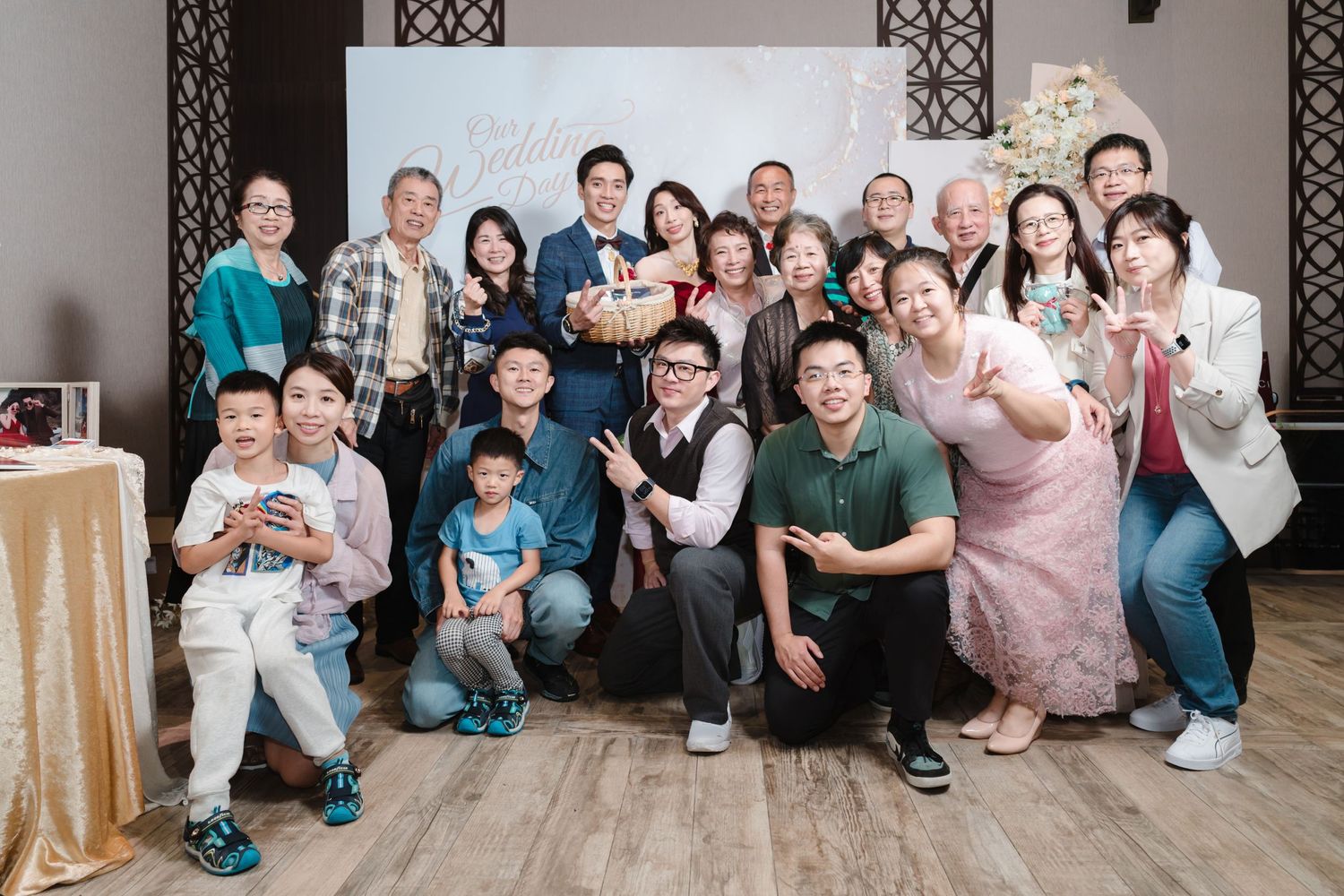 Large group photo of people gathered together in a casual indoor setting, posing and smiling for the camera.