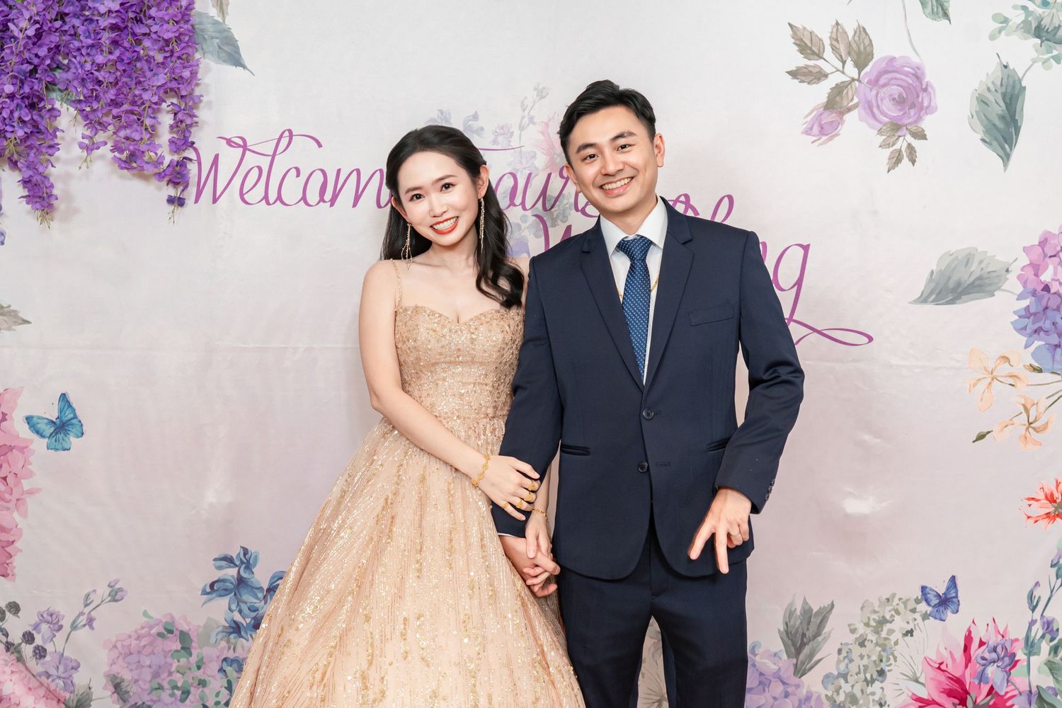 Formal celebration setup with floral backdrop featuring purple blooms and decorative elements.
