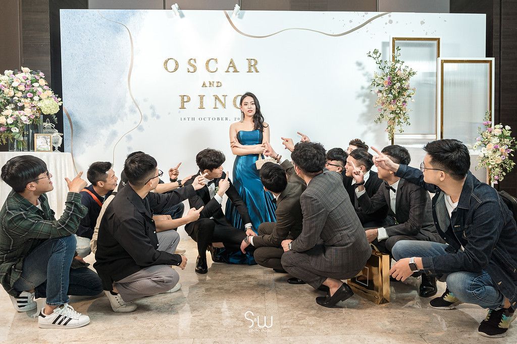 Photographers capture shots of a couple at their wedding reception against an elegant white and gold backdrop.