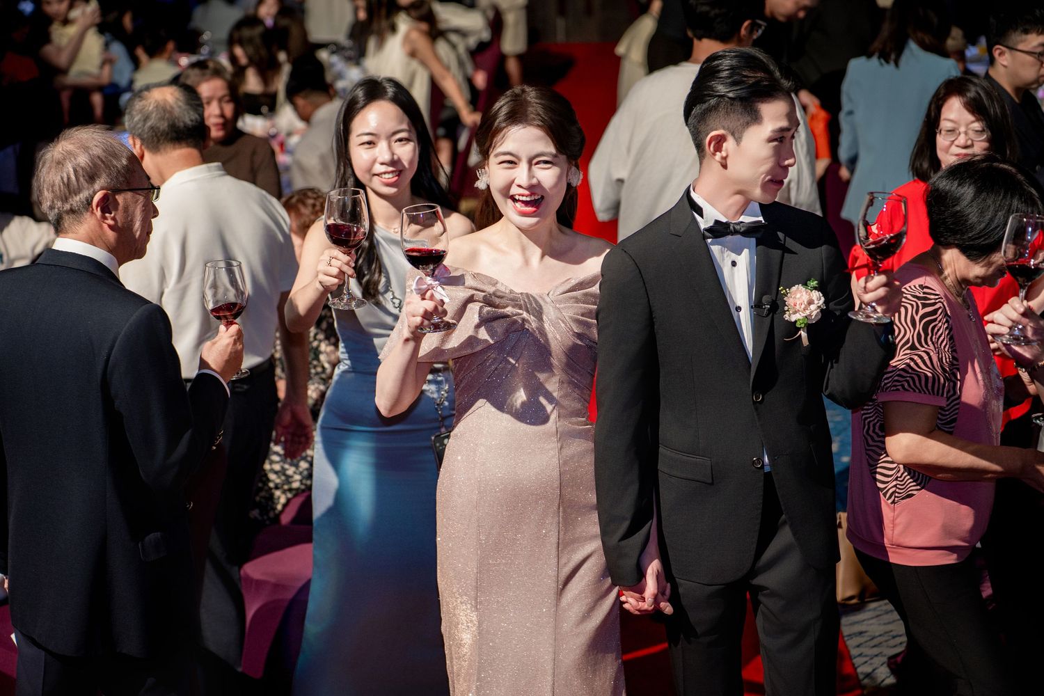 Wedding guests at an upscale celebration enjoy a lively moment during the reception in formal attire.