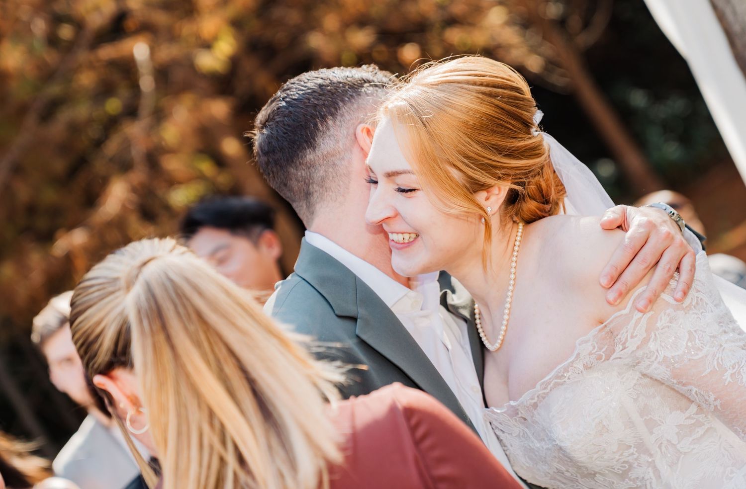 Candid emotional moment captured during outdoor fall wedding celebration.